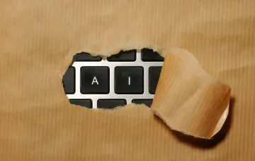 Tastatur, die eine Holzoberfläche durchbricht: Metapher für die neue Welle von KI-Kybersicherheitsbedrohungen, vor der OpenAI, Google und Microsoft warnen