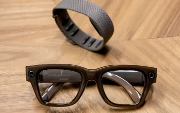Meta Ray-Ban Smart-Brille mit Kameras und Aufzeichnungsindikator auf Holzuntergrund