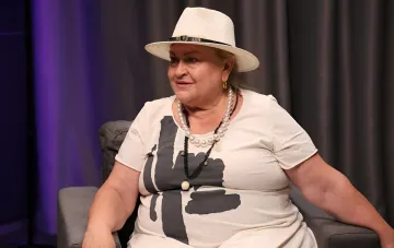 Nina Naboka in weißem Hut und Perlenschmuck im Studio, wo die Schauspielerin ukrainische Stars anhand von Kinderfotos erkennt