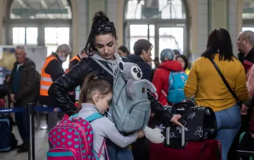 Українська біженка з дитиною та багажем у черзі в Польщі на тлі новини про допомогу 800 Плюс