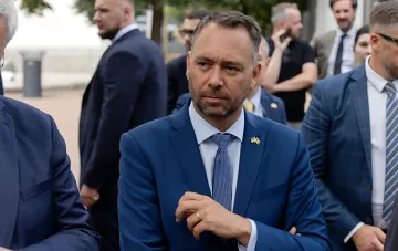 KI-generiertes Foto eines Mannes im blauen Anzug mit belgischem Abzeichen, das einen diplomatischen Skandal zwischen den USA und Belgien auslöste