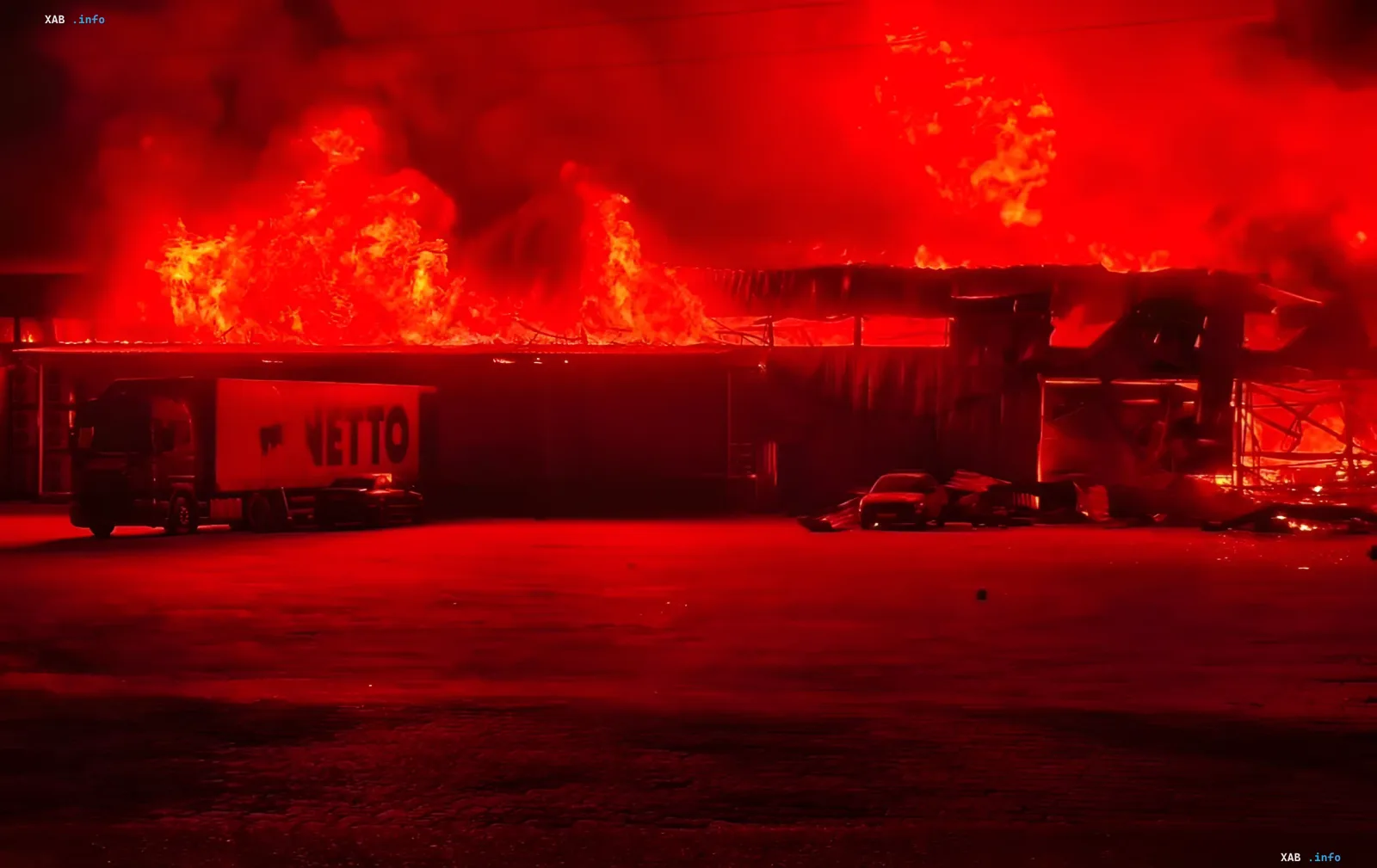 Fire at a logistics warehouse in Kyiv region after a strike: flames over the roof and a NETTO truck in the foreground