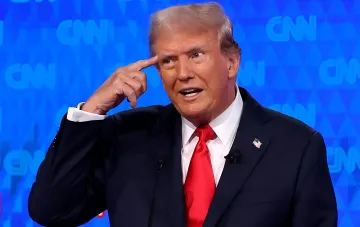 Дональд Трамп вказує пальцем на скроню на тлі логотипів CNN у момент, коли оголосив про перейменування озера Онтаріо в «озеро Америка», що викликало відповідь Джастіна Карні