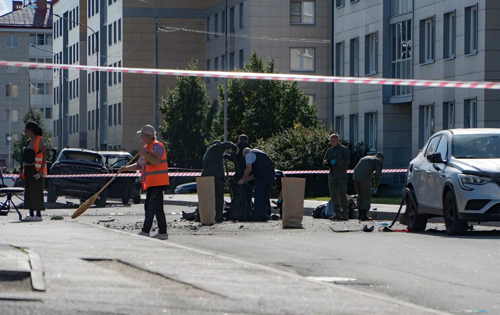 Ort der Autodetonation in Sankt Petersburg: Rettungskräfte in orangefarbenen Westen und Soldaten räumen Trümmer hinter dem Absperrband