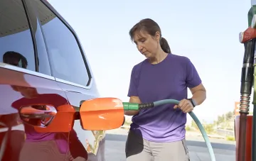 Woman refueling a car with gasoline at a gas station amid rising fuel prices in Ukraine in August 2026