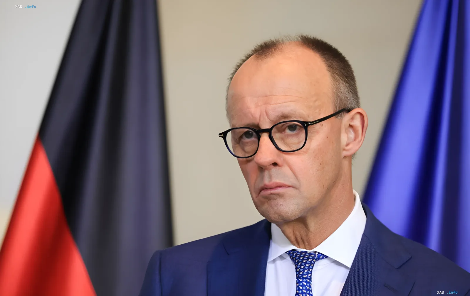 Friedrich Merz im blauen Anzug vor der deutschen Flagge: Kanzler bereitet breite Sanktionen gegen Russland nach dem Drohnenvorfall in Leipzig vor