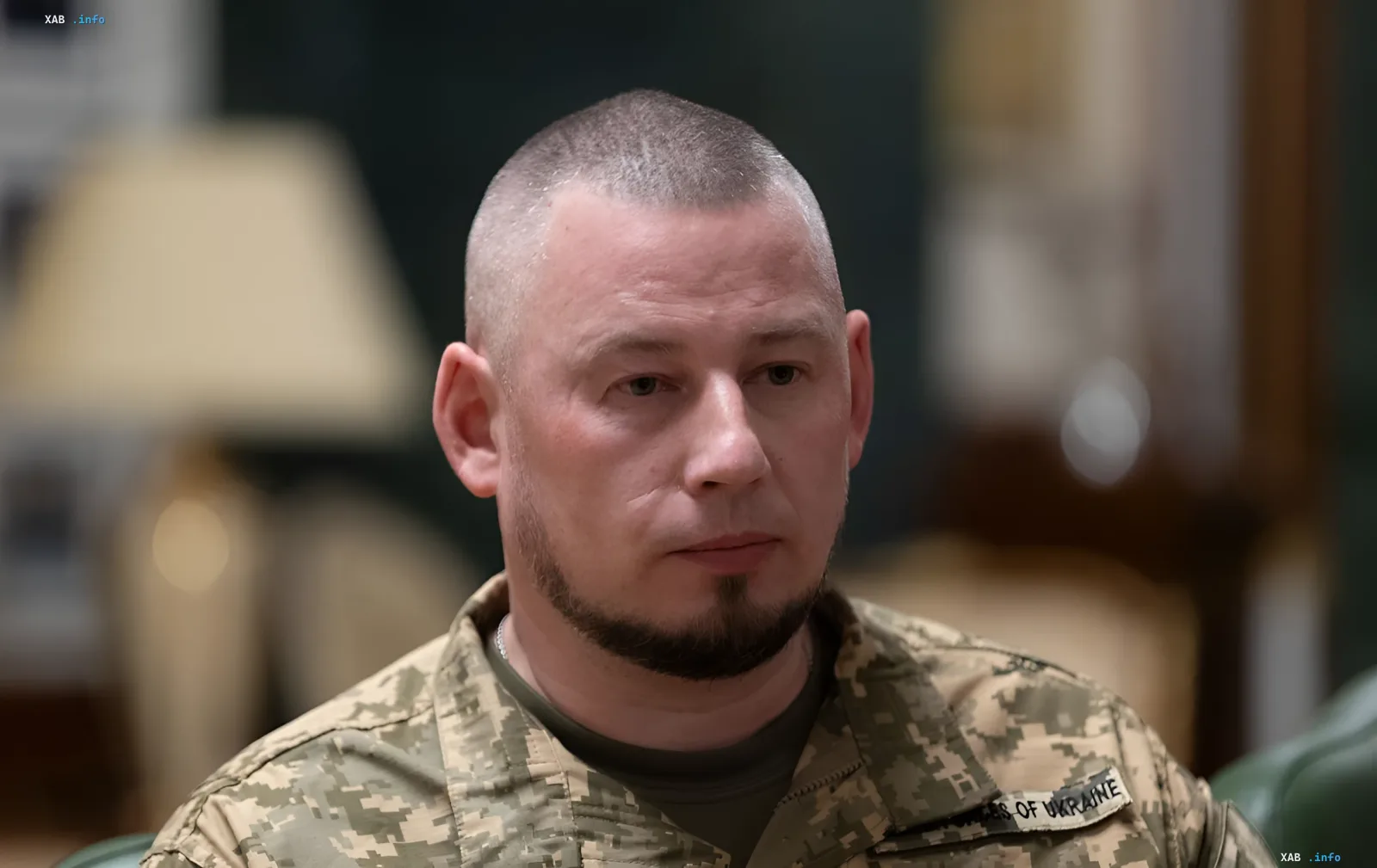 Украинский военный в камуфляжной форме с нашивкой ВСУ на фоне интервью о проблемах ПВО с реактивными дронами РФ