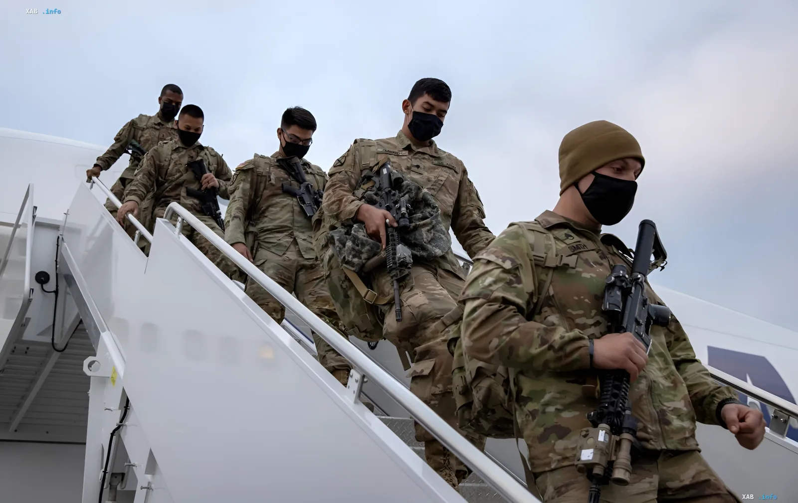 Военные в камуфляжной форме с автоматами спускаются по трапу самолёта, иллюстрируя сценарий переброски сил в Европе