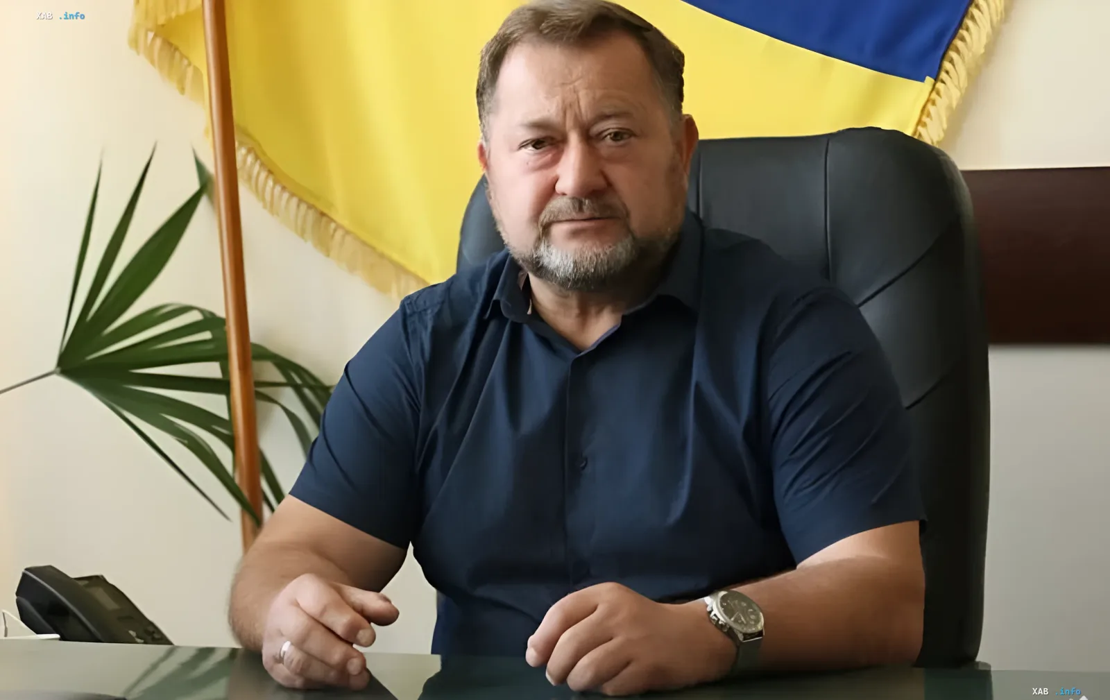 Тарас Дидич, глава Дмитриевской общины на Киевщине, погибший при российской атаке, за рабочим столом на фоне украинского флага
