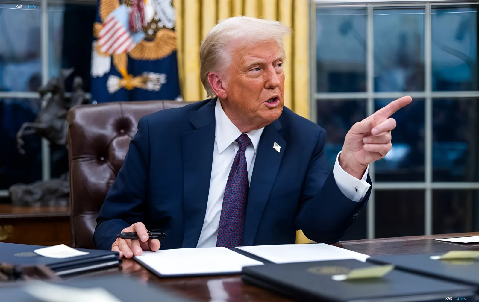 Дональд Трамп за столом в Овальном кабинете указывает пальцем во время объявления о крупнейшей нефтяной сделке с Венесуэлой