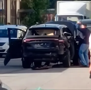 Beschädigtes Auto am Ort der Explosion in Sankt Petersburg: zerbrochenes Glas, offene Türen und Menschen neben dem Fahrzeug