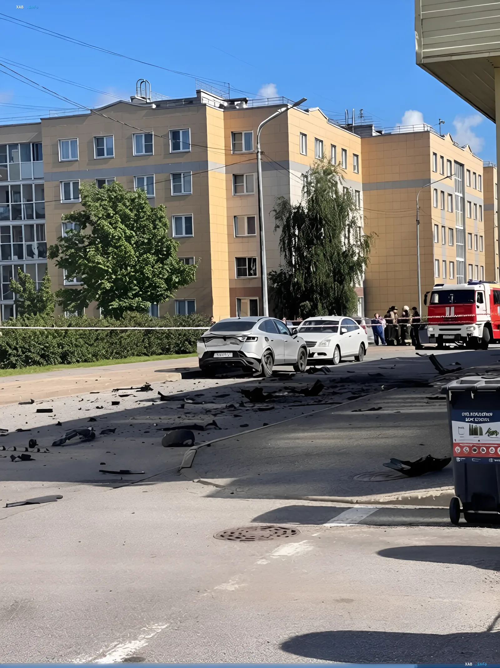 Folgen einer Autodetonation in Sankt Petersburg Ort einer Autodetonation in Sankt Petersburg: beschädigtes weißes Crossover-Fahrzeug, Trümmer auf dem Asphalt und ein Feuerwehrfahrzeug nach dem Tod eines Oberstleutnants der russischen Luft- und Raumverteidigung