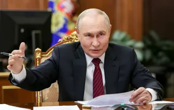 Володимир Путін за робочим столом на тлі карти світу — контекст російської політики та допомоги Україні