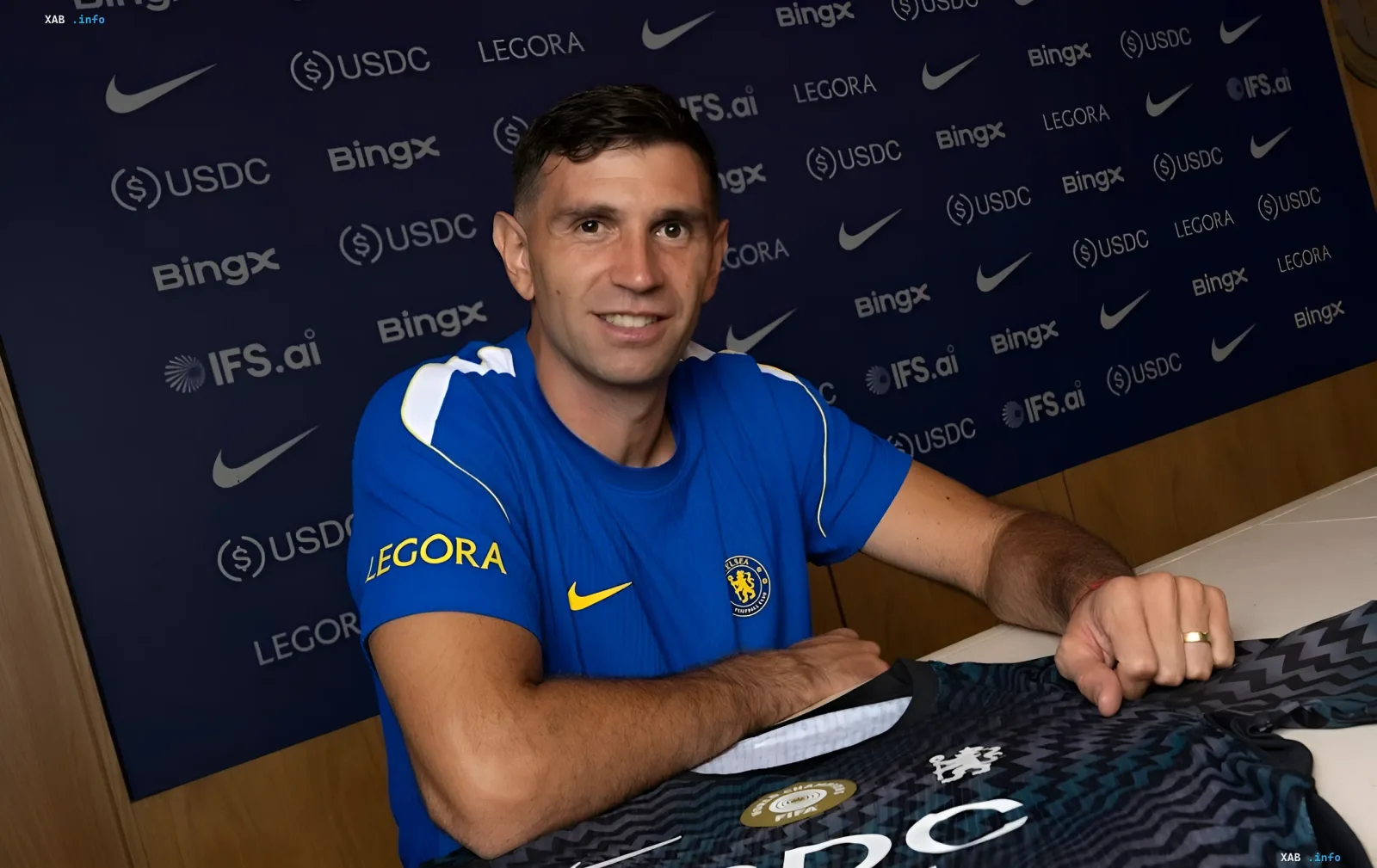 Emiliano Martinez in a Chelsea kit at the official contract signing ceremony