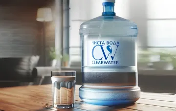 Бутылка питної води бренду «Чиста вода» (Clearwater) і склянка з водою на дерев'яному столі — виробництво зупинено після російського удару по Милі