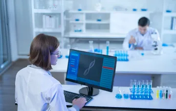 Scientist analyzing DNA data on a computer in a lab for genetic passport creation