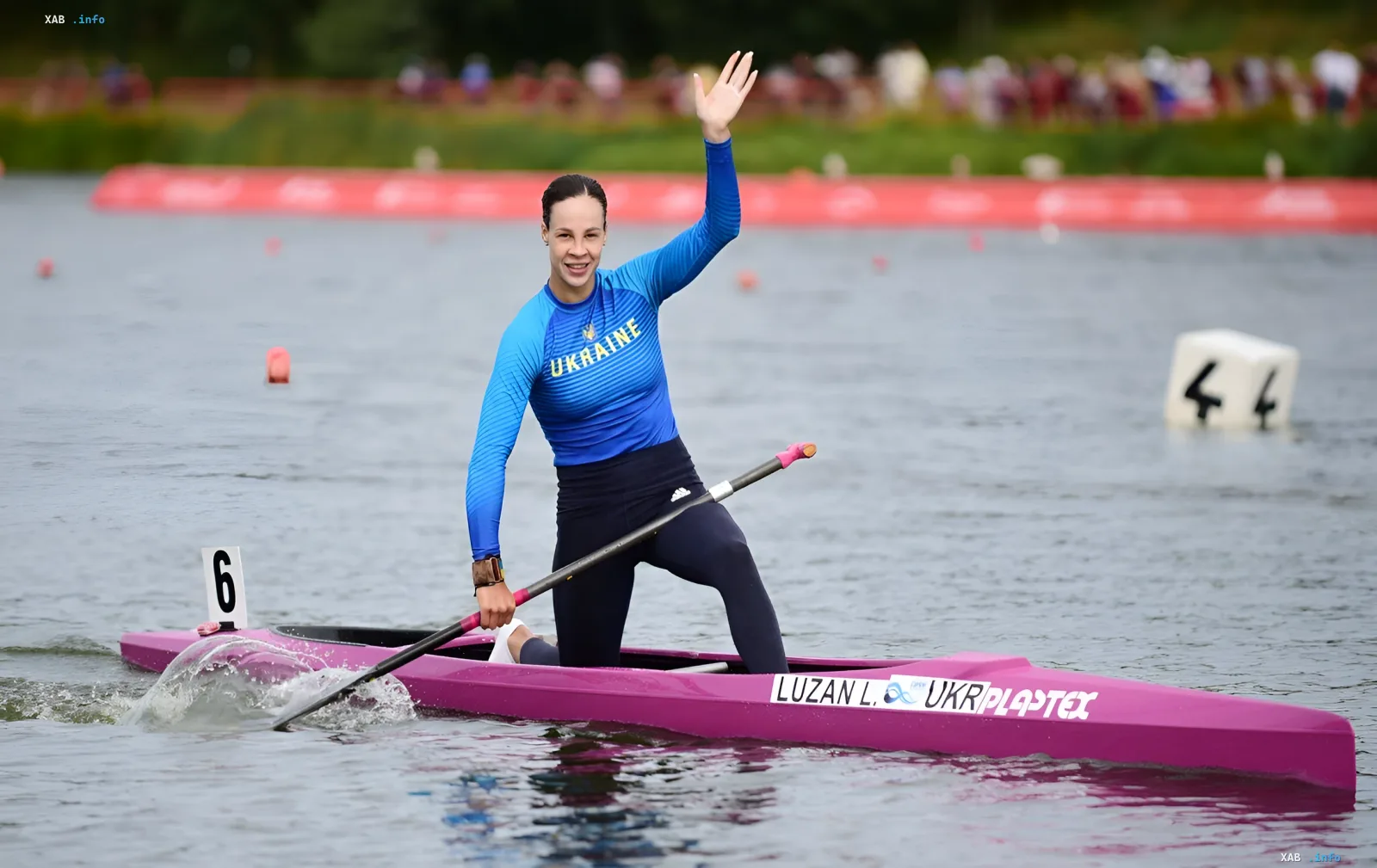 Lyudmyla Luzan in the Ukraine national kit waves to spectators in her kayak after winning gold at the 2026 World Rowing Championships