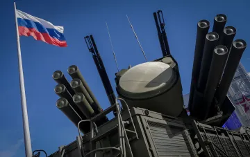 Russian air defense missile system with launch canisters and radar against the Russian flag, in the context of MoD statements on preparing strikes on Ukraine's energy infrastructure