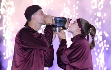 Muhova and Menšík kiss the trophy after winning the mixed doubles at US Open 2026