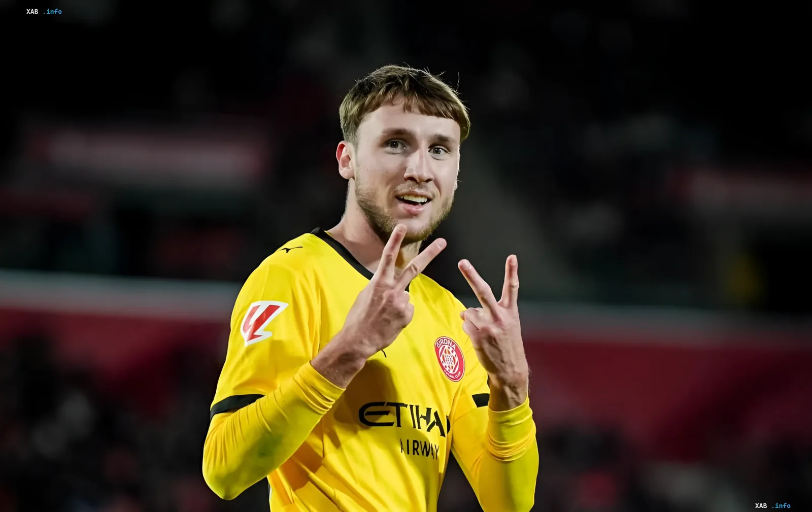 Ukrainian player Vanat in a yellow Girona kit celebrating after his assist in the La Liga match against Las Palmas, making a distinctive hand gesture