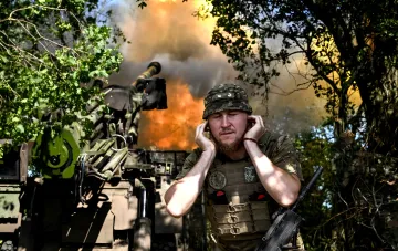 Боец ВСУ закрывает уши на фоне артиллерийского огня в Сумской области, где опровергнут захват Великого Прикола и Садков