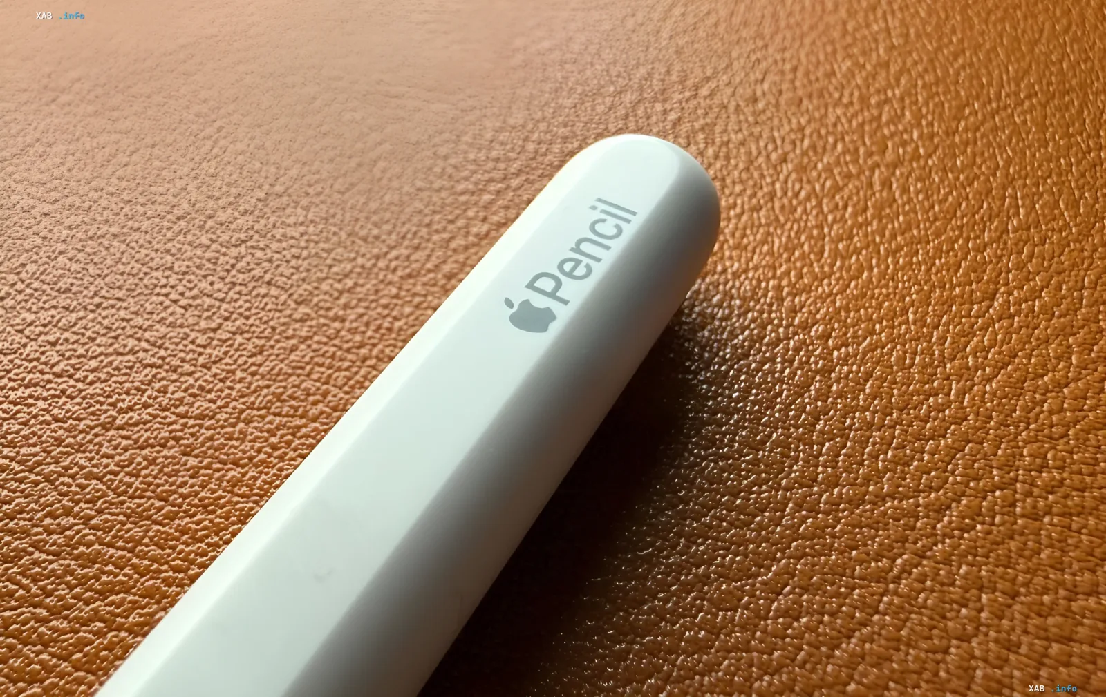 Короткий и толстый прототип Apple Pencil для складного iPhone на коричневом кожаном фоне