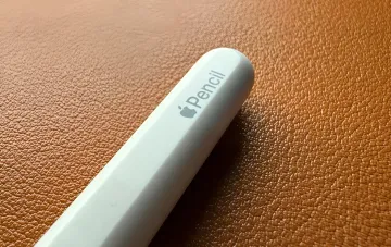 Короткий и толстый прототип Apple Pencil для складного iPhone на коричневом кожаном фоне