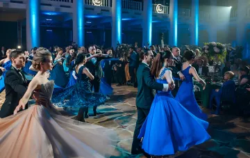 Пары танцуют вальс на Charity Viennese Ball во Львове: гости в вечерних нарядах и сапфировых платьях на паркетном зале