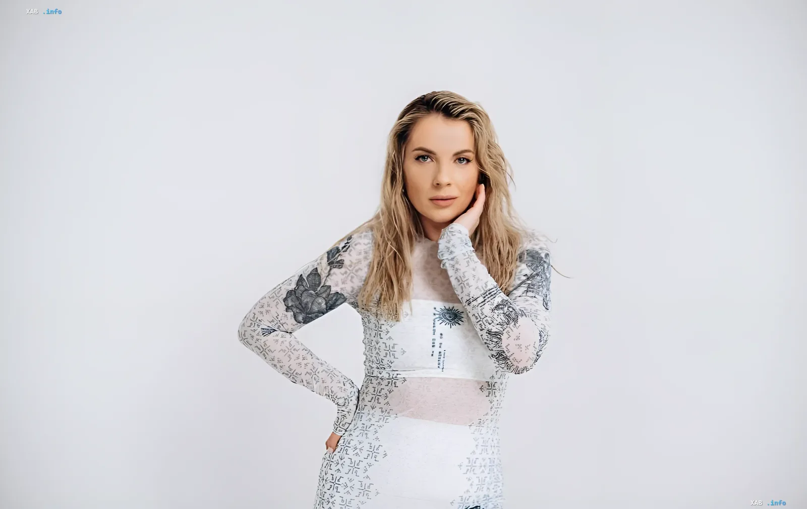 Kristina Prysiazhnuk in einem weißen gemusterten Kleid im Studioporträt für ein Interview über Beauty-Routine und die Geschichte des Liedes „Derzhavna“