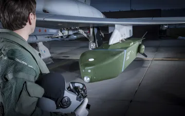 Militärperson am Flügel eines Kampfjets mit angebrachtem Waffensystem im Kontext der Debatte über die Lieferung von Taurus-Raketen an die Ukraine