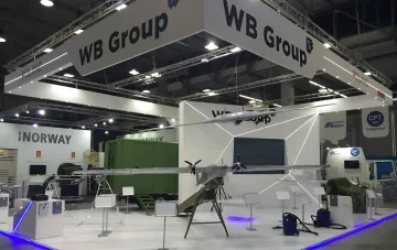 Exhibition stand of Polish company WB Electronics featuring unmanned aerial vehicles at a defense trade show