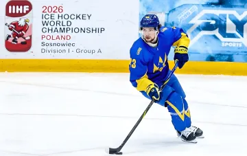 Хокеїст збірної України у синій формі на льоді під час матчу IIHF World Championship Division I в Сосновці