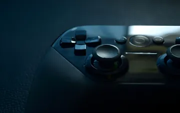 Dunkle Gamepad vor dem Hintergrund der 12-GB-Steam-Datenleak mit frühen Builds von Portal 2, Left 4 Dead 2 und CS:GO von Valve