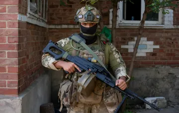 Ukrainian soldier with rifle during a sudden infantry offensive on the Kupyansk direction, clearing the forest southwest of Zakhidne