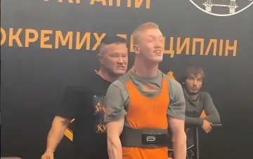 Дмитрий Полович с ДЦП в оранжевой экипировке после рекордного подъёма штанги 107,5 кг в становой тяге