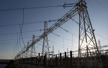 Power station and transmission towers at sunset: Ukraine's energy grid under threat from chronic energy market debts