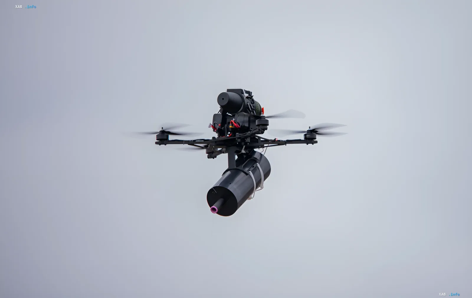Militärer Quadrocopter-Drohne mit aufhängtem Modul im Flug — Illustration zum Glasfaserdrohnen-Ausschreibungsverfahren und zur NABU-Beschwerde