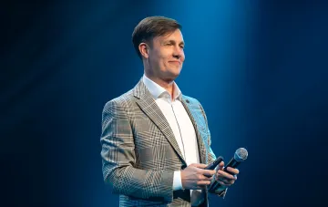 Письменник Макс Кидрук на сцені з мікрофоном під час виступу про заробіток літератора та літературний успіх