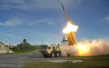 Запуск ракеты зенитного ракетного комплекса Patriot с колёсной пусковой установки на фоне огненного факела и дыма — иллюстрация контрактов Пентагона на наращивание производства ракет Patriot и THAAD