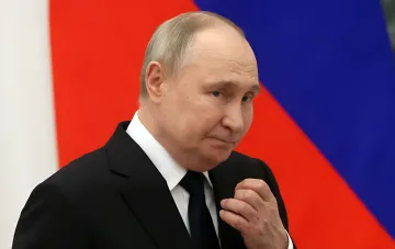 Vladimir Putin in a contemplative pose against the Russian flag as he calls Ukraine negotiations 'effectively frozen' yet leaves the door open to Trump's envoys