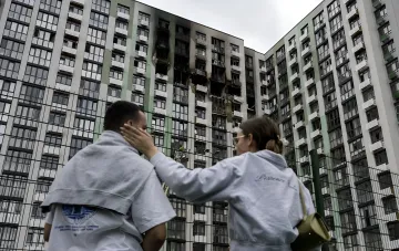 Bewohner beobachten Schäden an einem Wohngebäude in Kiew nach russischem Drohnenangriff