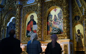 Молитва вірних перед позолоченими іконами в православному храмі — ілюстрація до церковного календаря ПЦУ на вересень 2026 року