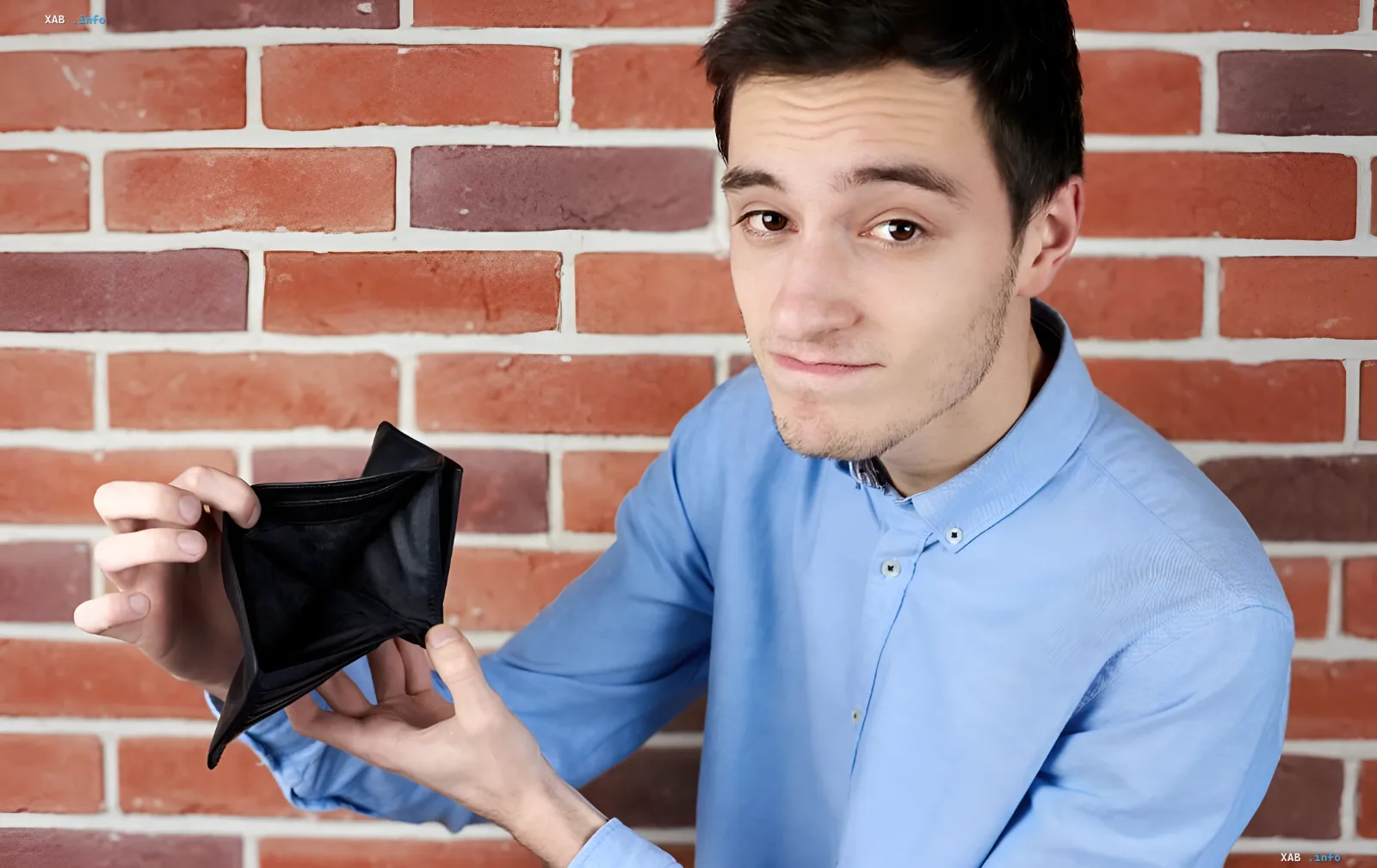 Man showing an empty wallet against a brick wall — illustration for article on how Ukrainians survive on a low salary