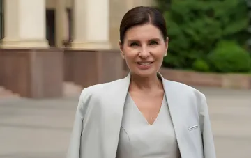 Kahanowska in einem hellen Business-Anzug vor dem Gebäude der Karasin-Universität vor der Rektorenwahl