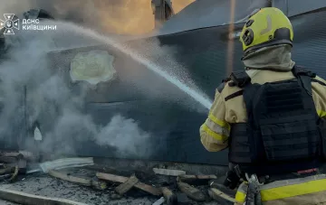 Feuerwehrmann löscht ein Feuer an einem nach Drohnenangriff beschädigten Gebäude in Kiew