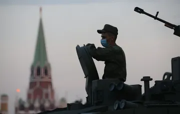 Российский военный в маске на бронемашины на фоне московской башни — символ давления в когнитивной войне