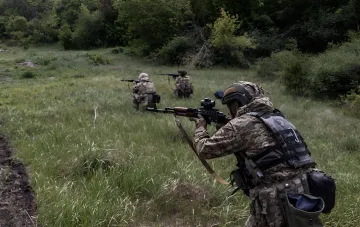 Бойцы полка «Скала» и корпуса «Азов» в ходе совместных боевых действий: военнослужащие в камуфляже ведут огонь из винтовок в полевых условиях