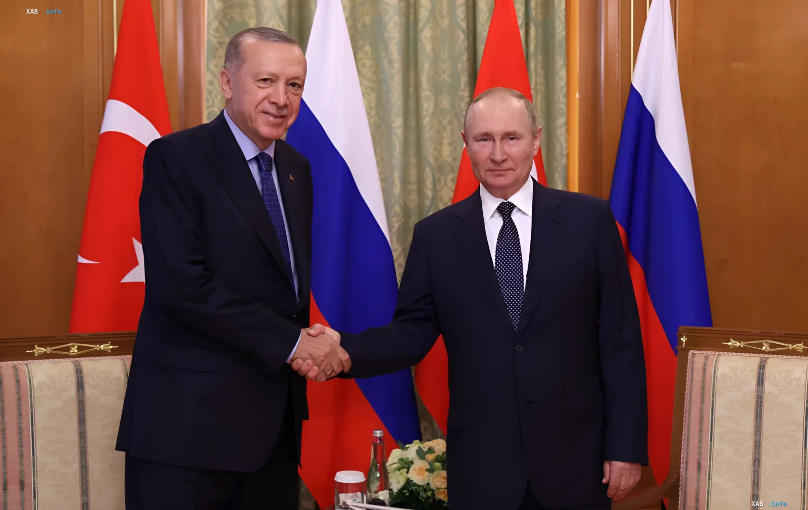 Путин и Эрдоган пожимают руки на закрытых переговорах саммита ШОС на фоне флагов России и Турции