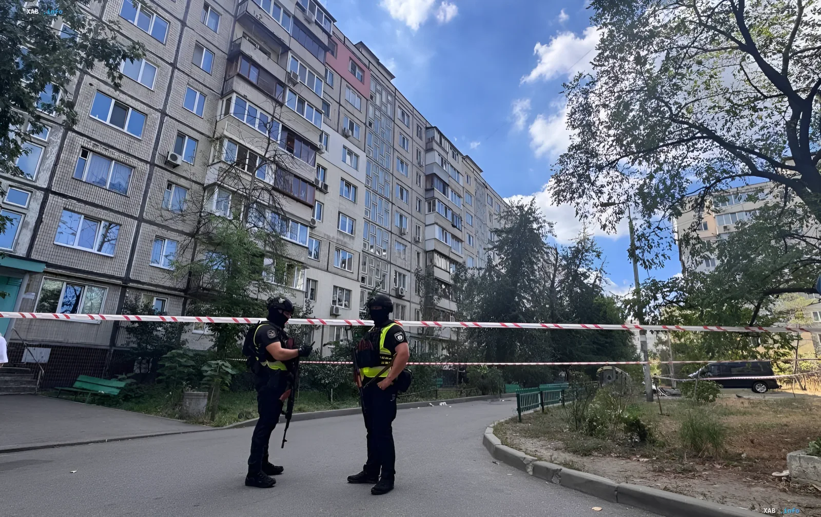 Вооружённые сотрудники в тактической экипировке у оцепления на фоне жилого дома в Киеве во время перестрелки между СБУ и ГУР