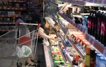 A shopper selects eggs on a supermarket shelf amid rising prices in Ukraine
